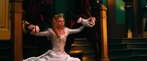 Glinda being chained by two Winkie guards.