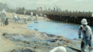 A HAZMAT team cleaning a beach covered in Kaiju Blue.