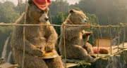 Lucy and Pastuzo eat marmalade sandwiches on a bridge (Paddington 2)