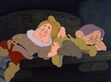 Sneezy and Dopey sleep on the bench