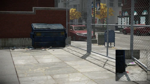 6. Between the garbage bin and the fence near the main entrance