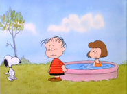Snoopy is about to blow Linus into Patty's pool