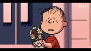 Linus holds a mug with flowers in Lucy's School
