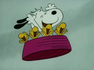 Snoopy and his bird friends waving their arms flying in the air while they are seated at Snoopy's dish