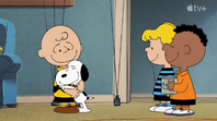 Snoopy hugs Charlie Brown as Franklin and Schroeder watches them