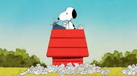 Snoopy tries to type something in the typewriter with paper all over the place