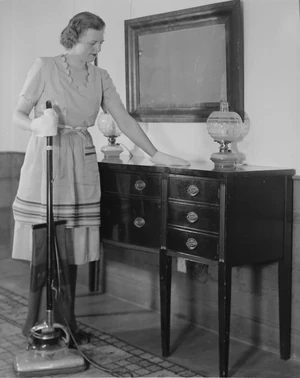 Woman dusting and using a vacuum cleaner, 1920-1954. Photo by U.S. Department of Agriculture. Courtesy Wikimedia Commons.