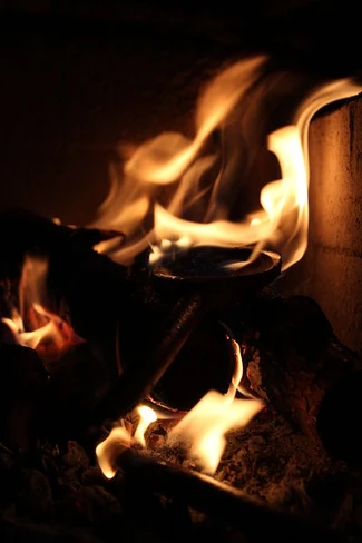 Fire in the hearth, 2014. Photo by Anna Reg. Licensed under Creative Commons, courtesy Wikimedia Commons.