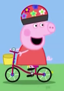 Peppa on her bike (note:In early animations of this, Peppa was not wearing a helmet.)