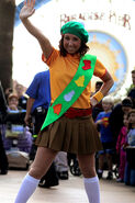 Fireside Girl dancer wearing a holiday sash and beret.