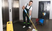 man standing near elevator doors, holding mop