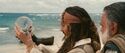 Captain Jack Sparrow (Johnny Depp) tries to figure out how to release his beloved Black Pearl from a bottle, as first mate Joshamee Gibbs (Kevin McNally) looks on.