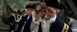 Commodore Norrington looks through his spyglass to see the Dauntless being taken by Jack Sparrow and Will Turner.
