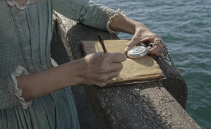  scrive delle annotazioni sul diario durante il viaggio.