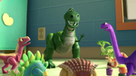 Rex surrounded by a red Velociraptor, teal Stegosaurus, brown Ankylosaurus, purple Apatosaurus, and light green Parasaurolophus