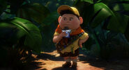 Russell eating his chocolate bar in the jungle.