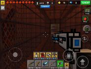 A big empty room with a book shelf on one side and a cage-like corridor down the middle.