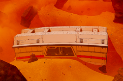 A wrecked cargo bay half buried in the dunes in the west.