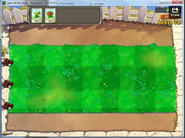 An early screenshot of Level 1-2. Notice the different Plant selects, Money counter, the different "Menu" button, and the Lawn Mowers.