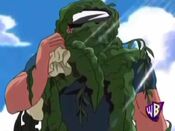 A man, covered in seaweed, appears