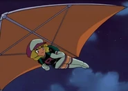 Domino using a hang glider to fly away.