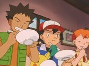 Ash, Misty and Brock eat the food at a fast pace