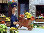 Pat pushing a wheelbarrow of flowers