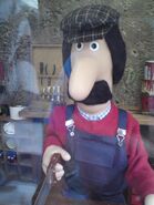 Ted sawing a piece of wood in his workshop
