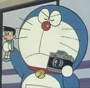 Doraemon (Doraemon) uses his futuristic gadgets to punish wrongdoers. In this situation, he uses the Cursing Camera to capture a voodoo doll of Suneo...