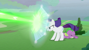 Rarity protects Spike with magic shield S9E25