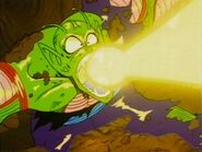 Piccolo (Dragon Ball) firing a blast of life-force energy from his mouth to pierce through Son Goku's shoulder.