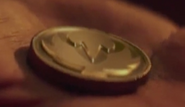 The Crimson Hawk Power Coin in Tommy's hand in the live action short, Power Rangers Legacy Wars: Street Fighter Showdown