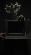 Bigger Body Pianosaurus behind one of the computers/televisions Harley Sawyer can control.
