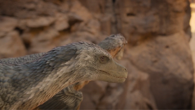 Velociraptors observing prey from atop a cliff in the sun-baked badlands of Mongolia