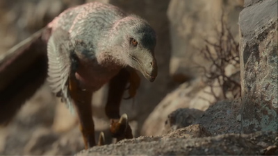 A Velociraptor sneaking up by the side of a cliff