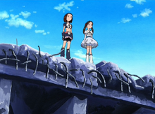 Natsuko and Kyoko stand on top at the edge of a soon-to-be-demolished building.