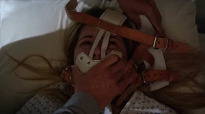Archer placing a new restraint on Alison