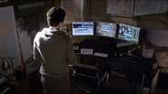 The surveillance system from Ezra's lair in Ravenswood is seen in the basement of his cabin.