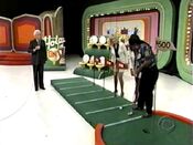 Bob rolls the ball towards Anita so he would not get hit with the putter.