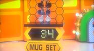 She bids $30 on the ceramic mugs & stand. A difference of $4. She picks card #25.