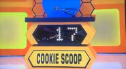 She bids $15 on the cookie scoop. A difference of $2. She picks card #20.