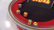 On her first roll, she has 3 cars and $2,000. She decides to roll again.