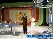 Bob hands the contestant the Price is Right dime she'll need in order to make her phone call.