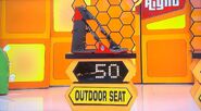 He bids $50 on the outdoor seat and is exactly right! And he automatically wins the Masterlock bike lock and the sleep mask. He picks cards #4, #23, and #27.