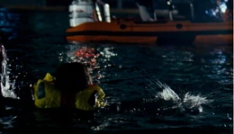 Jenny swims back to the boat, unaware that she is being chased by a 