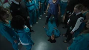 Staff and inmates surround the body of Drago after she is beaten to death