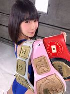 Asumi poses with the BWP Championship, Fighting Girls Championship, and BATTLE Queen Championship