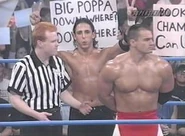 Lance Storm stands for the Canadian National Anthem while Kidman goofs around behind him.