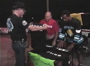 Norman Smiley and Ralphus are trying to sell some fake F. U. N. B. shirts.