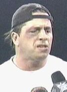 Bret Hart wearing a ponytail to show his "new" haircut.